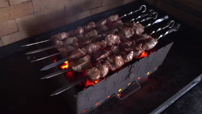 在外面的火盆上煮牛肉烤肉串。户外明火烧烤的特写烤肉串。在后院的晚宴上，在金属串上烧烤猪肉。