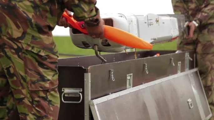 士兵们从箱子里拿出无人机。军事工程师准备监视无人军用飞机无人机进行飞行操作。商用空中监视或军用飞机。