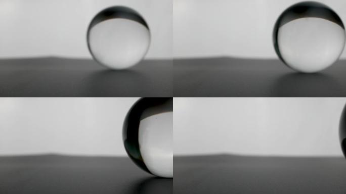 水晶玻璃球透明滚动在灰色渐变背景。
