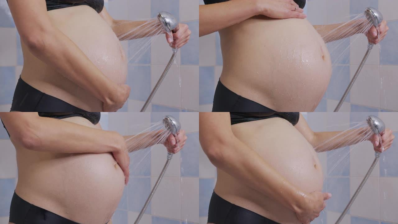 孕妇在洗澡时爱抚她的肚子。特写。