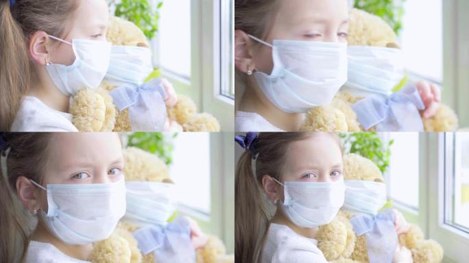 检疫在家预防冠状病毒大流行。泰迪在检疫。一个带着她的泰迪熊都戴着面具的孩子呆在房间的窗户旁边
