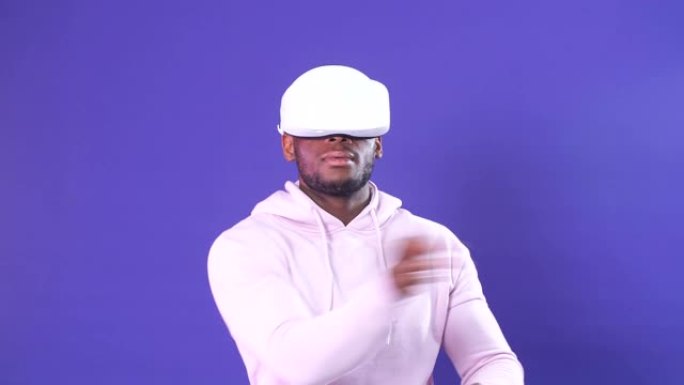 深蓝色背景下玩VR游戏的非洲裔美国年轻人的肖像
