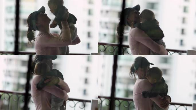 母亲怀抱婴儿的剪影爱的关系。妈妈和婴儿透过窗户反射看到