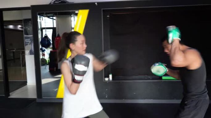 与教练一起练习女子拳击拳。