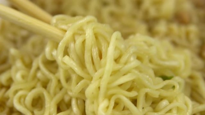 方便面是用中国筷子混合的。酿造的黄色拉面特写