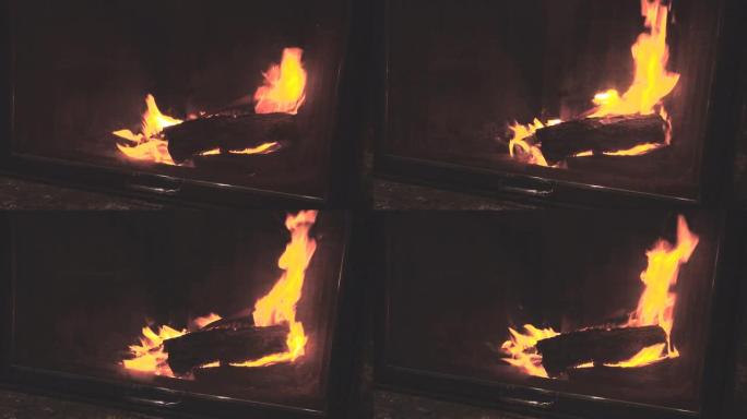 燃烧的火和木头的火。壁炉中燃烧的大火的特写镜头，黑暗的背景