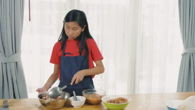 亚洲女孩在碗里用大豆汤腌制鸡肉，慢动作