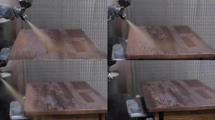木匠在polivizator的帮助下将清漆涂在木制桌面上。在木工车间工作。生产家具。
