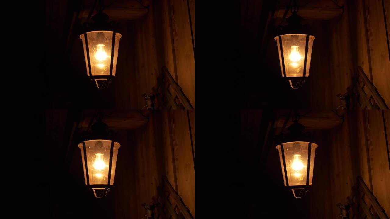 村庄谷仓附近的黑暗夜晚，一个古老的灯笼悬挂着，它昏暗的区域，风在闪烁，阴影沿着木墙，不祥的气氛，黑暗