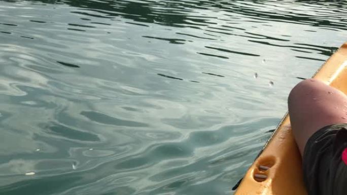 早晨，亚洲妇女在热带大湖皮划艇上晒太阳。放松运动