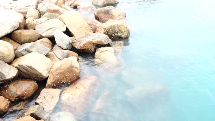 水晶透明亮光绿松石蓝色高架精神水波在岩石藤壶海壳上