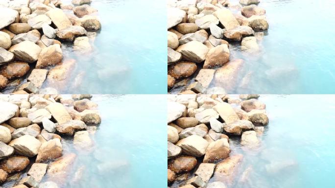 水晶透明亮光绿松石蓝色高架精神水波在岩石藤壶海壳上