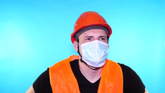 蓝色背景上戴着医用面具的年轻人的肖像。成年男性用口罩遮住脸，保护自己免受疾病侵害。冠状病毒流行病或疾