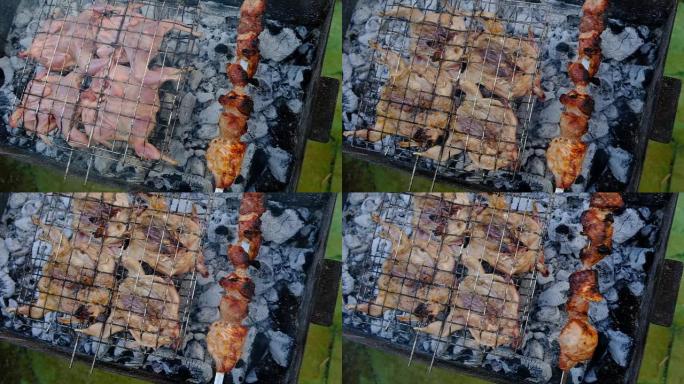 一个男人在燃烧的炭上烤猪肉串和鹌鹑。