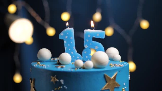 生日蛋糕15星天空和月亮概念，蓝色蜡烛被打火机点燃，然后吹灭。如果需要，请在屏幕右侧复制空间。特写和