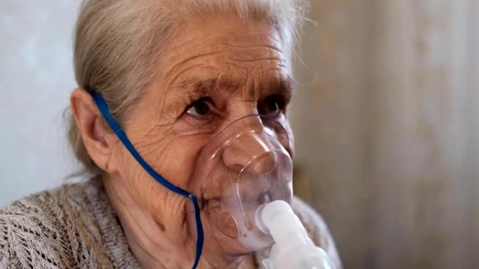 老年妇女用雾化器吸入的程序。