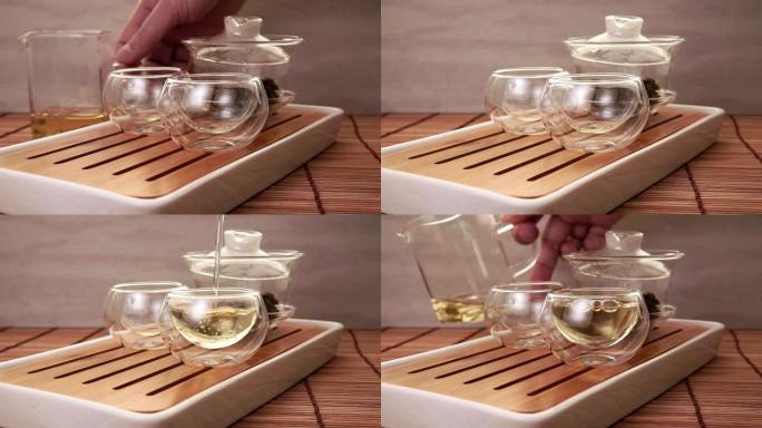 将中国绿茶从玻璃茶壶倒入一个小杯子中