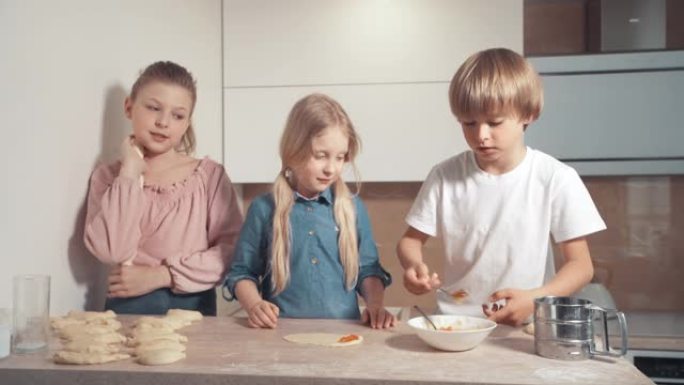 可爱的金发孩子准备厨房里的饼干。
