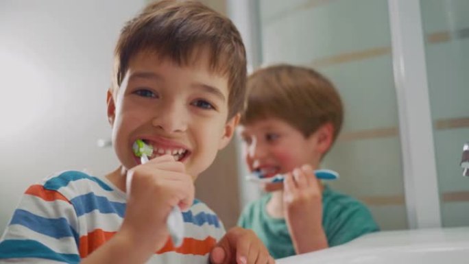 可爱的孩子正在刷他的小白牙，看着镜头
