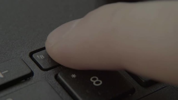 手指按下键盘上的声音上升按钮