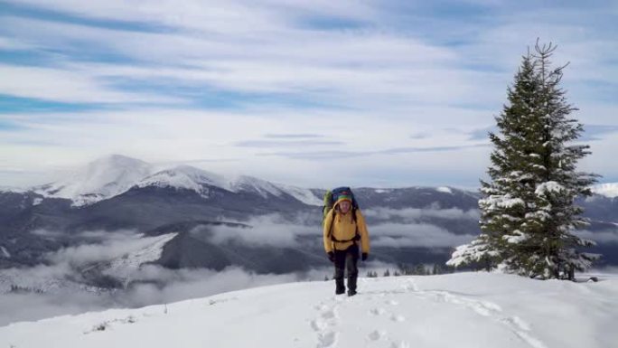 一个背着背包的男人冬天在山里旅行