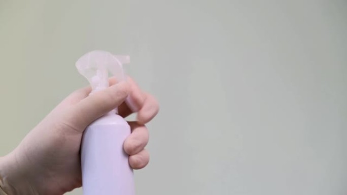 男子手保护乳胶手套使用消毒器喷雾房间消毒。