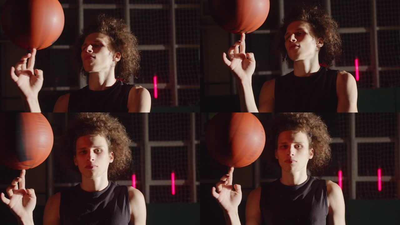 年轻的卷发高加索肖像篮球运动员准备好剪影在手指上旋转球明亮的光影技巧专业训练