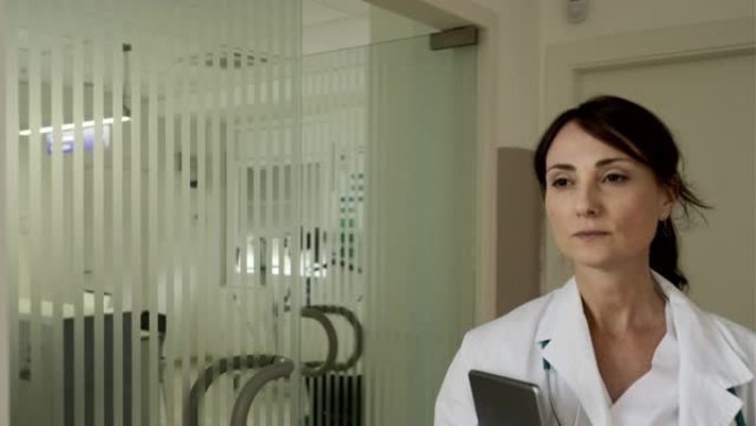一位女医生走在医院的走廊上。