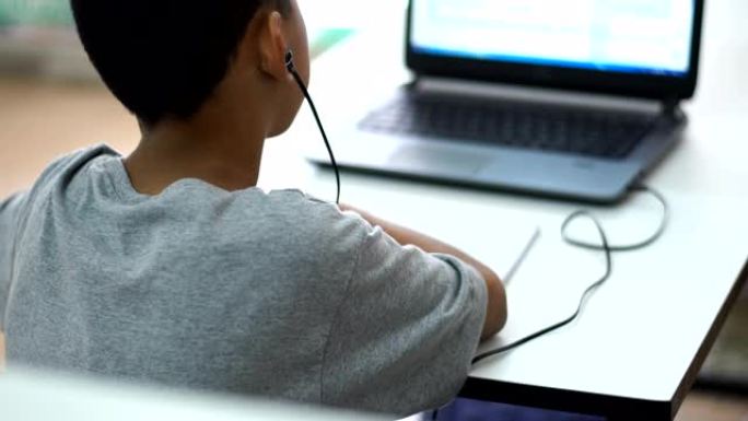 一个亚洲男孩在家在线学习。在2020年全球新冠肺炎疫情的关键时刻