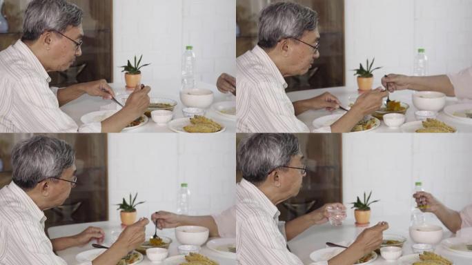 亚洲老年夫妇在家一起吃泰国菜带着幸福
