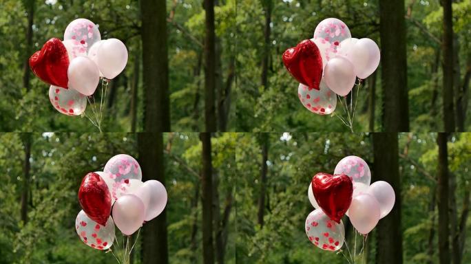 许多粉红色的氦气球和一个大的红色心形气球