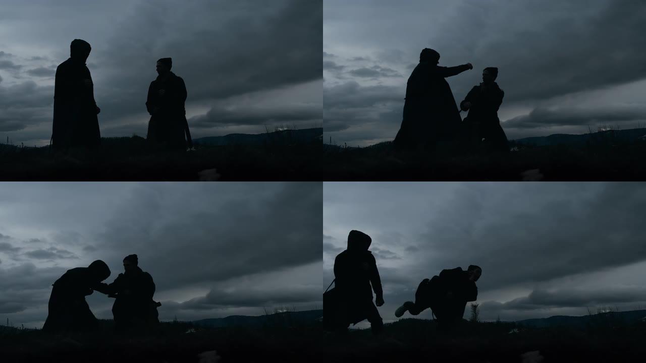 黄昏时，两个年轻人在多云的天空背景上。他们互相打架。