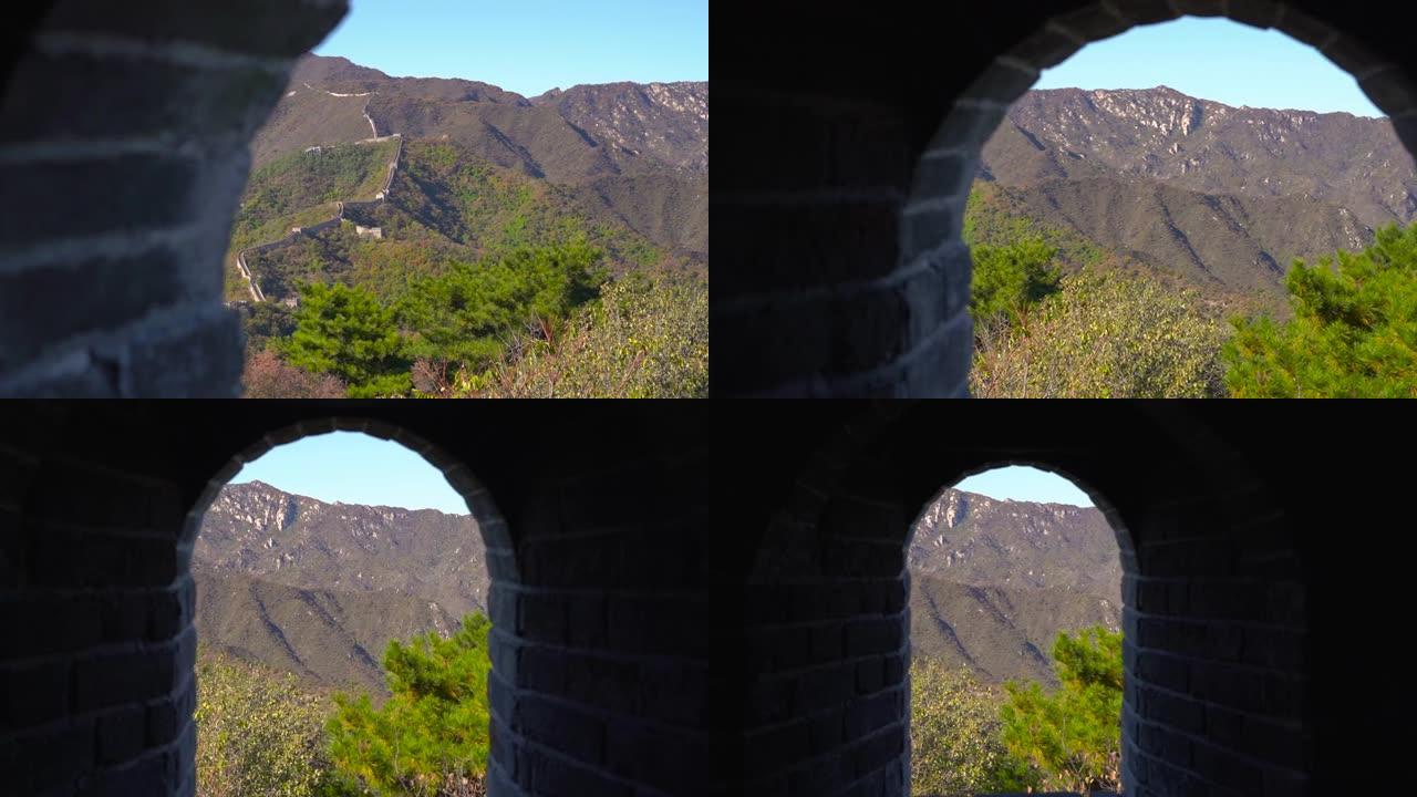 Steadicam拍摄了从山边升起的中国长城。摄像机在watch望塔的通道中移动，并从墙上的窗户显示