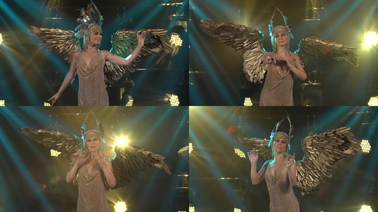 有着金色翅膀和别致头饰的希腊女神阿耳忒弥斯在舞台上载歌载舞。年轻女子表演戏剧声乐表演。特写