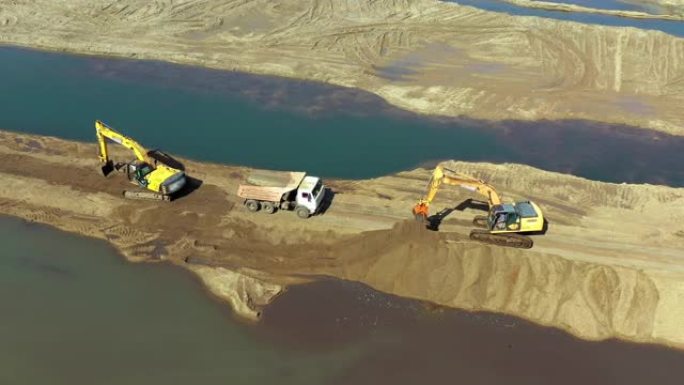 两辆黄色挖掘机的鸟瞰图，卡车在采石场工作。重型设备正在对土地进行分级。概念生产与建设