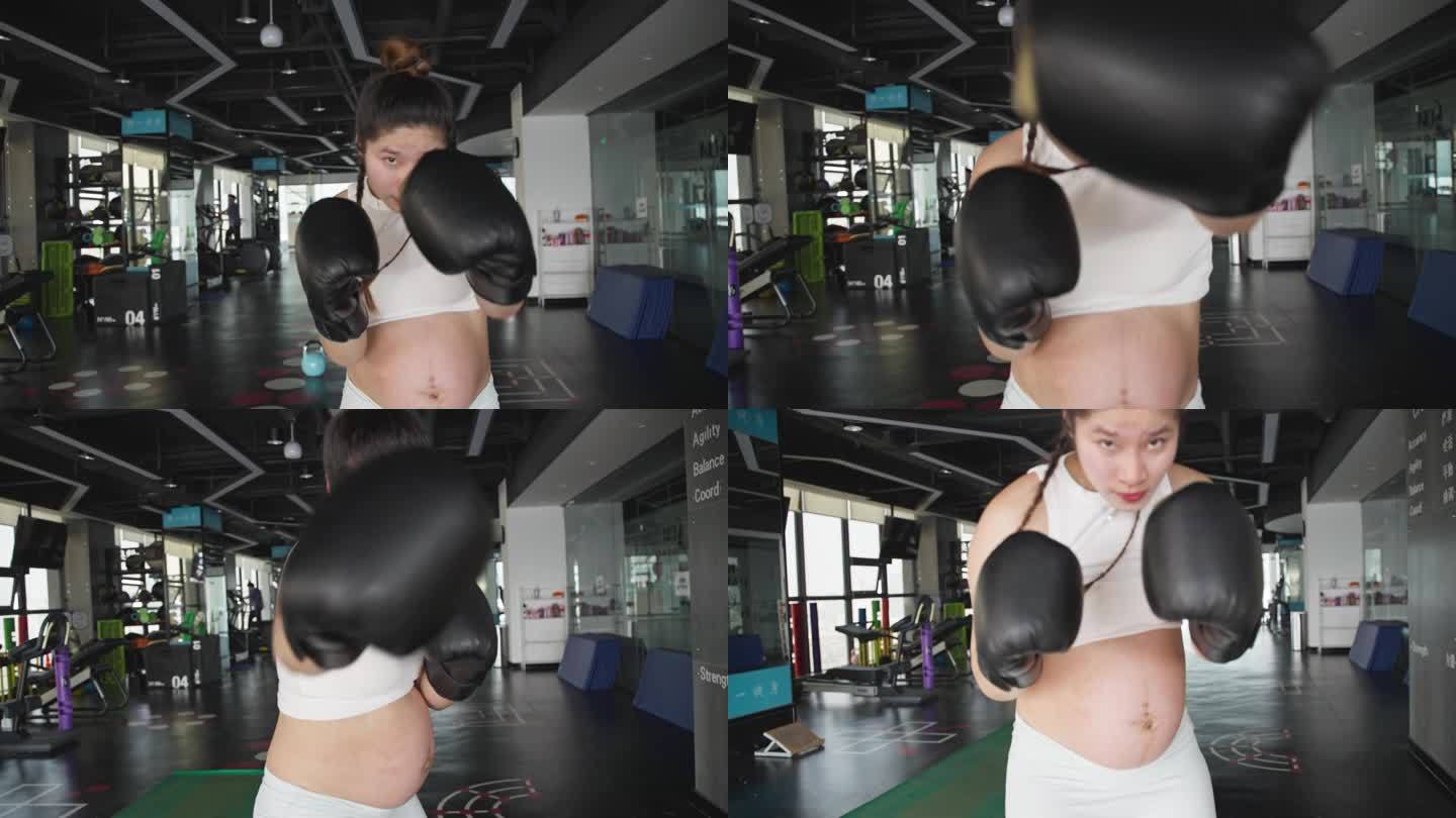 怀孕的现代女性在健身房锻炼身体打拳击