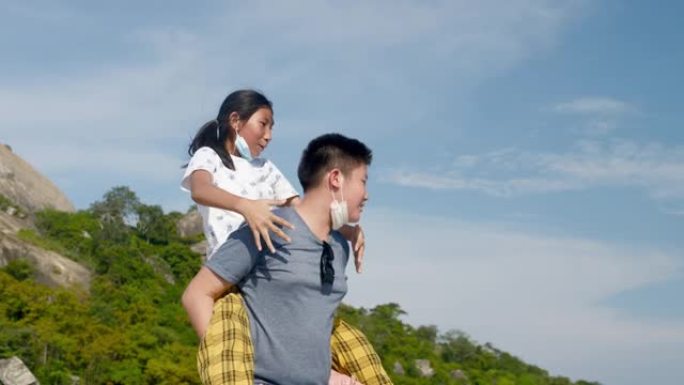 快乐的亚洲女孩在阳光明媚的日子里，在他们的旅行中，在天空和海景上piggy带她的哥哥，慢动作。