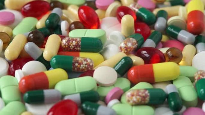 不同颜色的医用药丸的特写旋转成一圈。药丸和毒品。医药行业。医学概念。