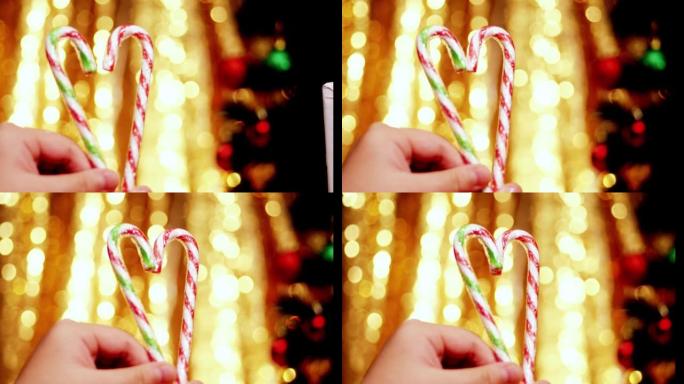 手握心形糖果棒，圣诞灯背景。