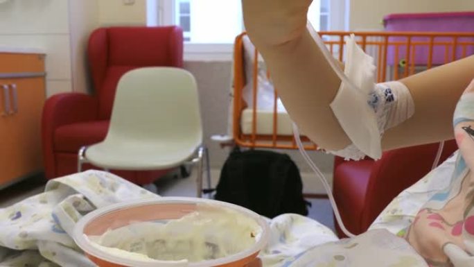 年轻女孩在医院用外周静脉导管打点滴吃饭