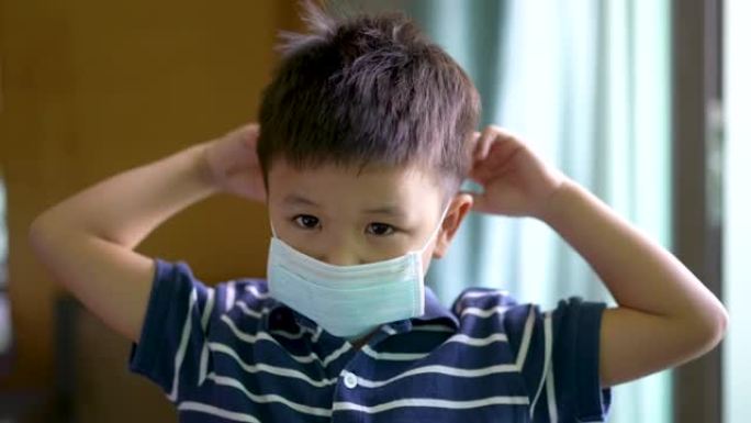 亚洲孩子在家戴口罩微笑。检疫的概念