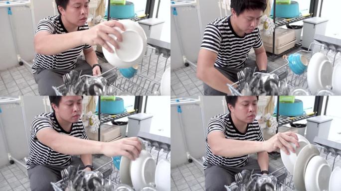 男子从洗碗机中取出干净的盘子。