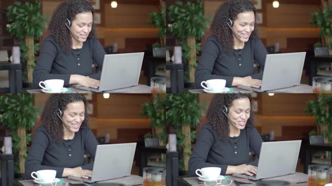 带着笔记本电脑微笑的非裔美国妇女正在进行在线对话