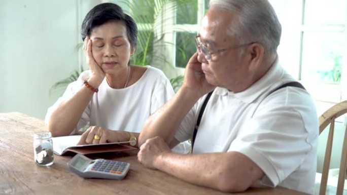 亚洲老年夫妇强调并认真计算计算器和金钱问题