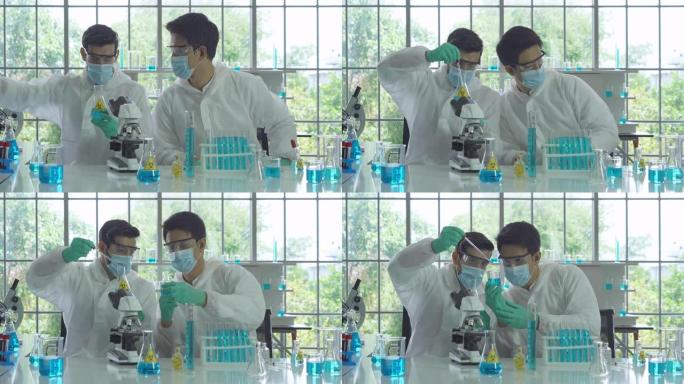 亚洲科学家致力于蓝色试管，在技术医学，化学，医疗保健，研究概念的实验室或实验室中分析和开发新型冠状病