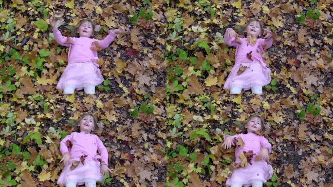 开朗的小女孩躺在秋天的落叶上