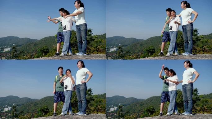 快乐的亚洲单身母亲和她的孩子一起享受山顶景观，冒险概念。