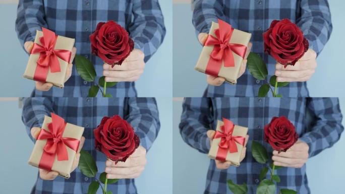 双手正在赠送带有红色蝴蝶结的包装礼物，朝相机移动，特写镜头。男人拿着小礼盒，手里拿着玫瑰去参加情人节