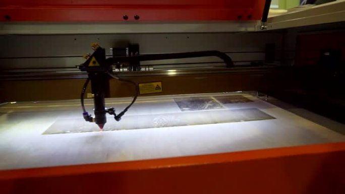 3D打印机激光束在木板上燃烧图案特写