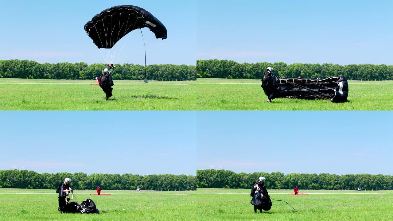 跳伞运动员降落在野外并收集降落伞。